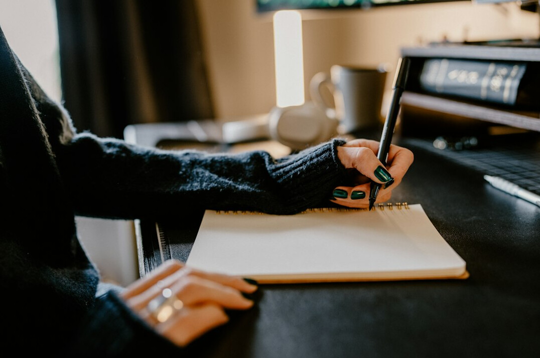 person writing goals in notebook